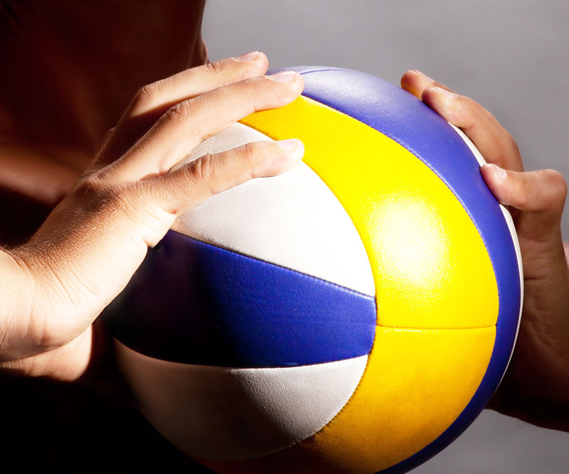 athlete holding a volleyball with both hands
