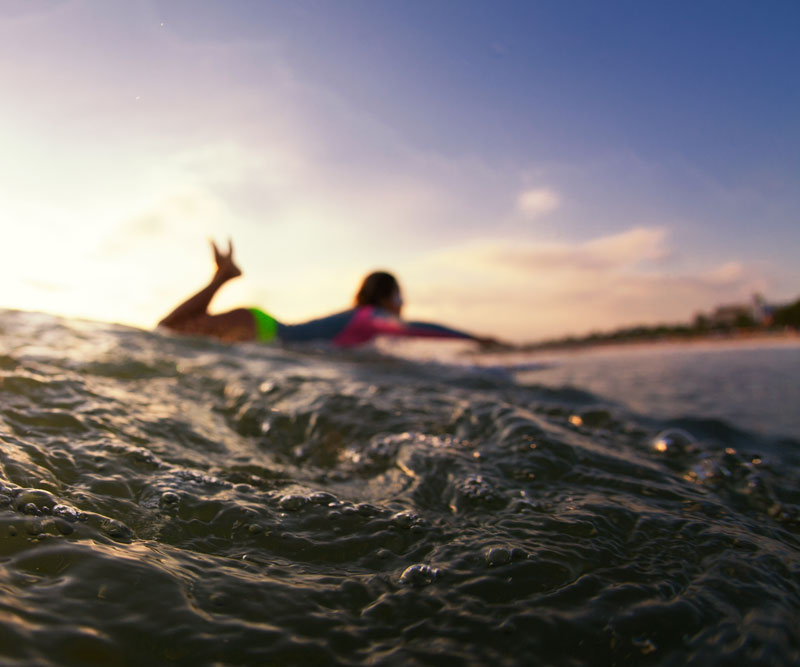 a surfer at sunrise