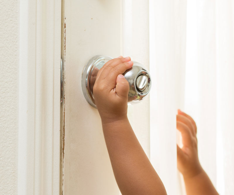 a risky child hand trying to open a door knob