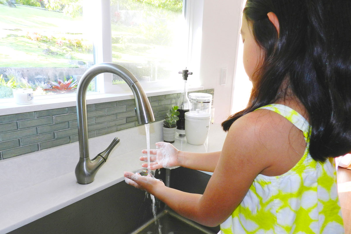 girl washing hands in a sink