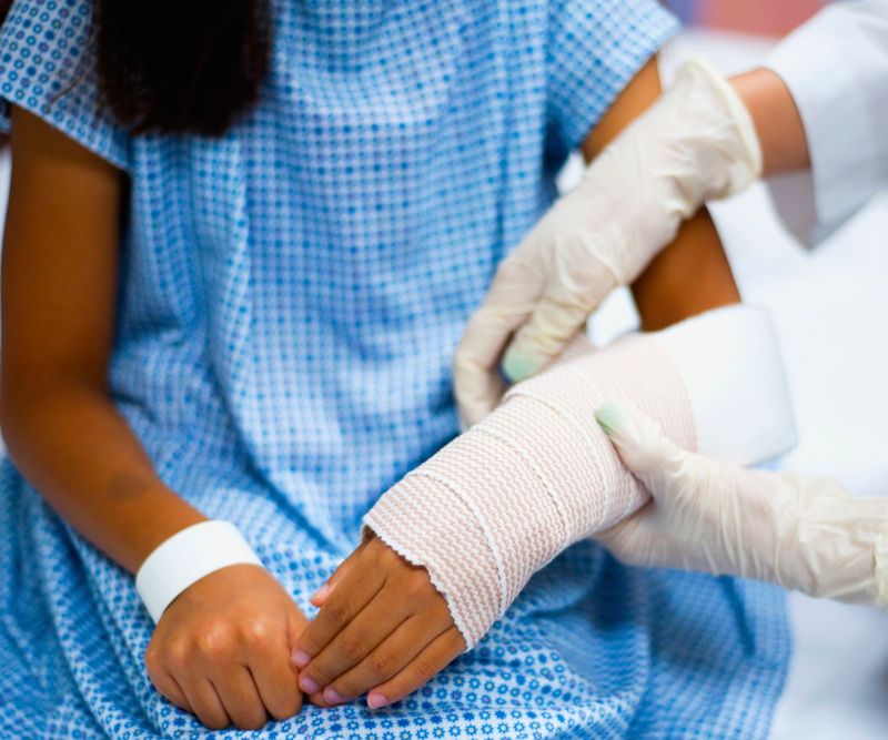 a young girl getting a cast applied by a doctor