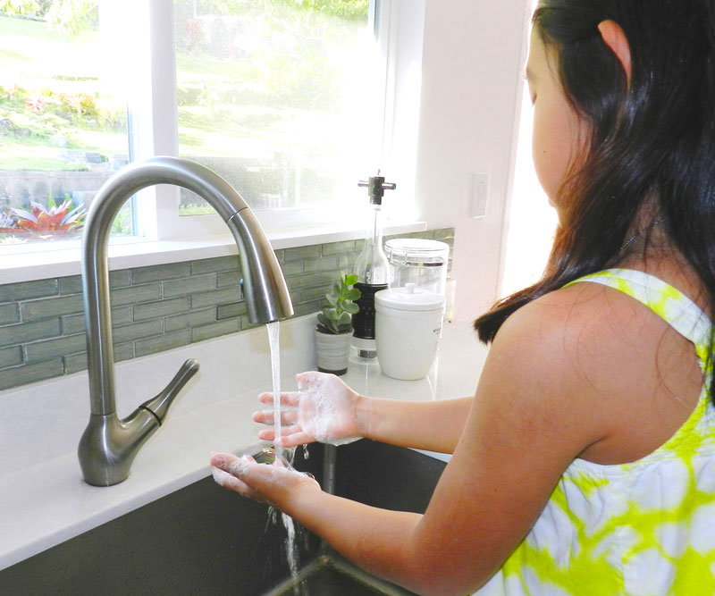 girl washing hands in a sink