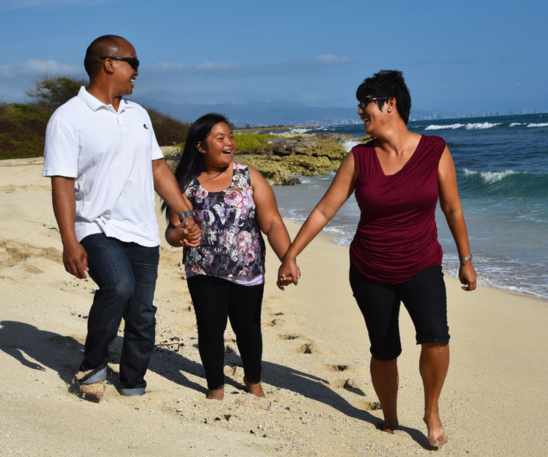 Family of three walking on the beach