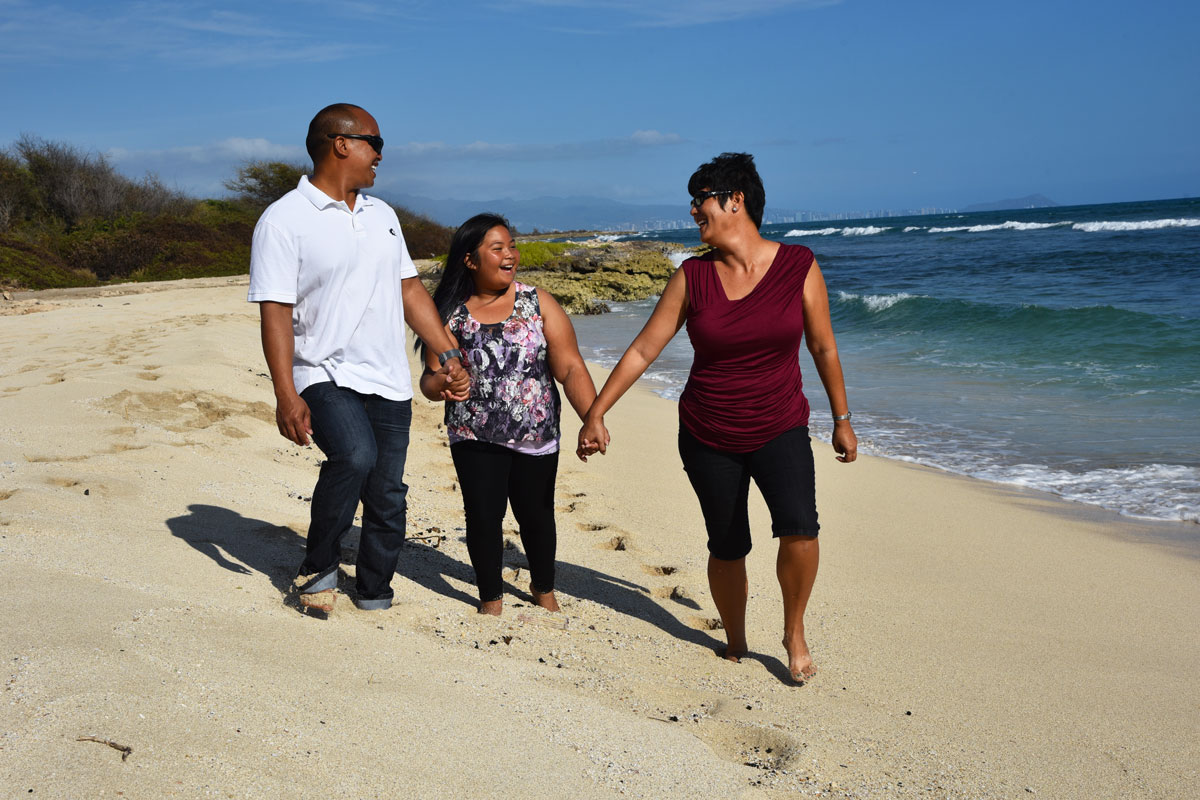 Family of three walking on the beach