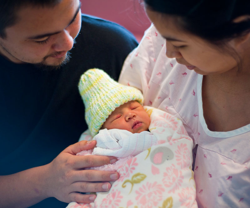 Two parents holding their newborn baby