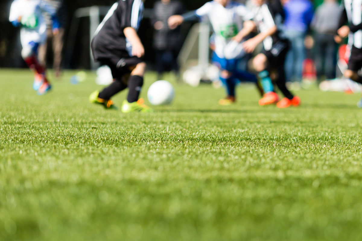 group of children playing soccer together