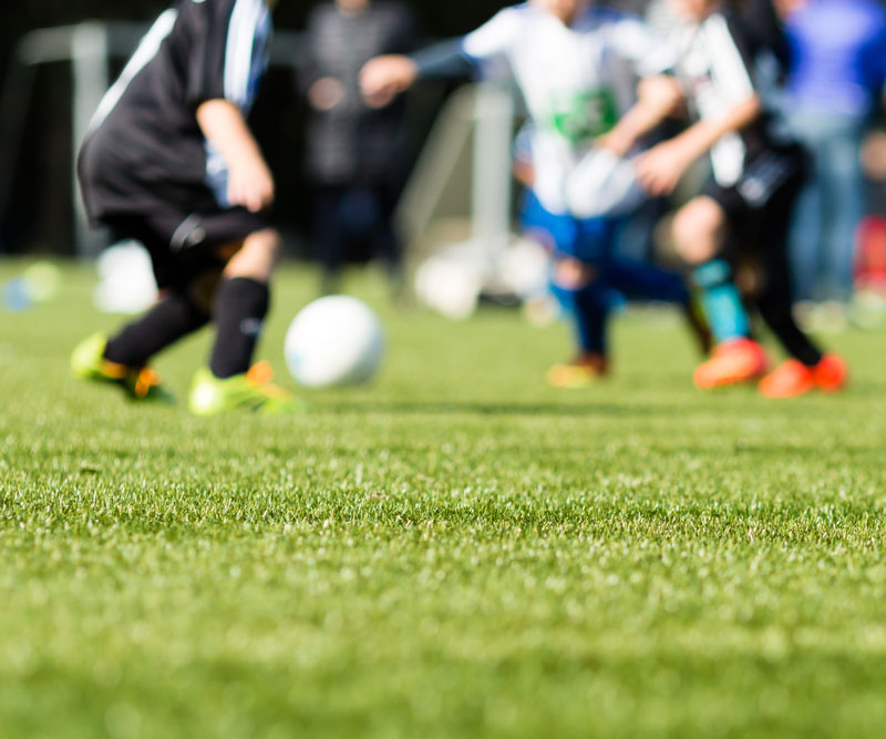 group of children playing soccer together