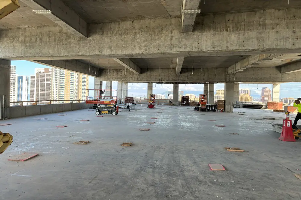 Open concrete floor on the makai side of Level 20 with equipment in the distance.