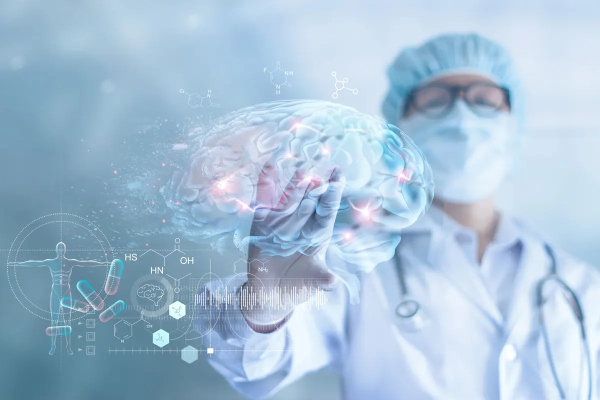 A doctor dressed in scrubs looks at a digital image of a brain with hot spots where neurons are firing.