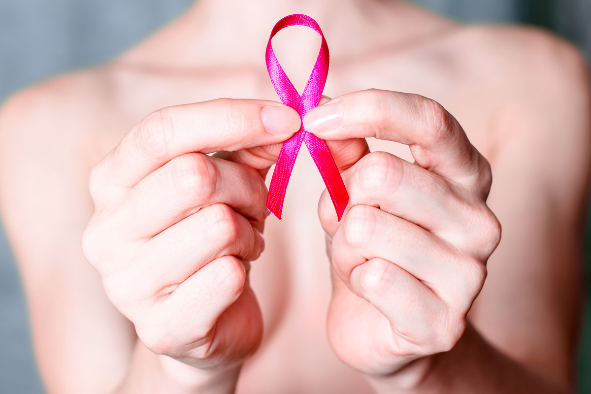 woman holding up a cancer ribbon