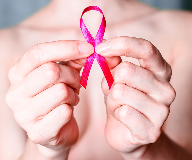 woman holding up a cancer ribbon