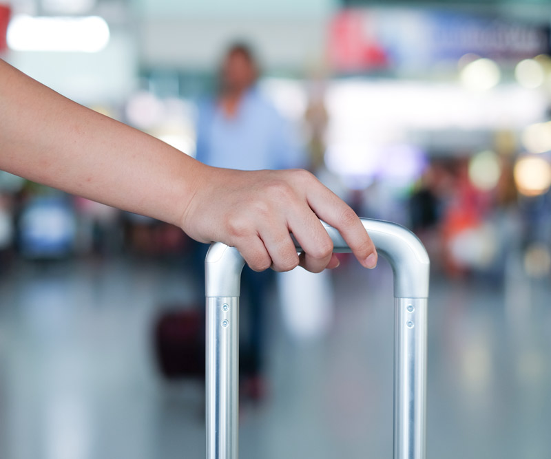 individual dragging suitcase through the airport