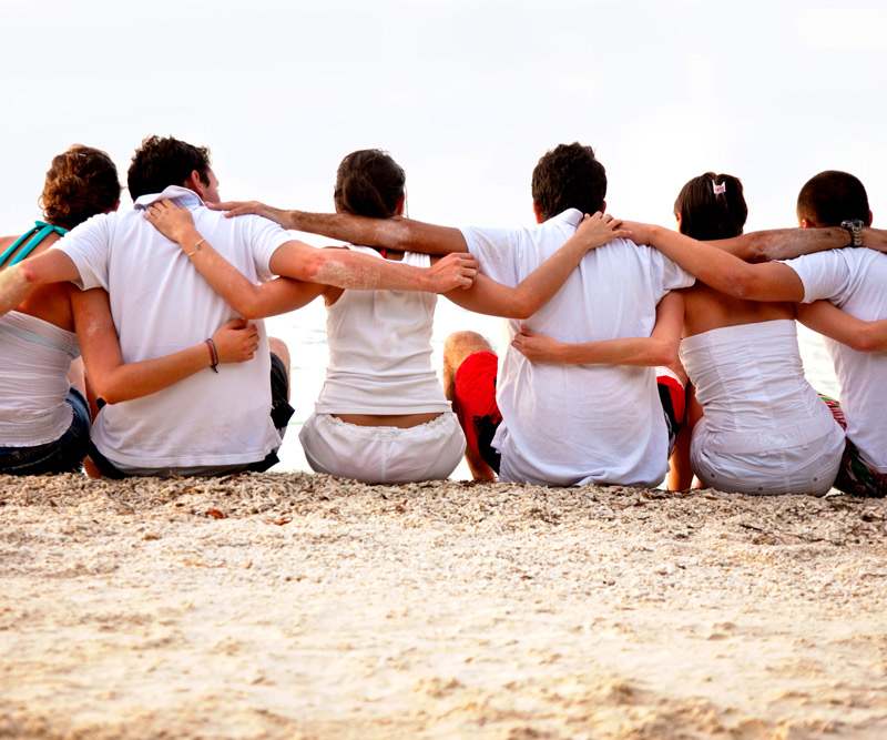 group of individuals embracing on the beach