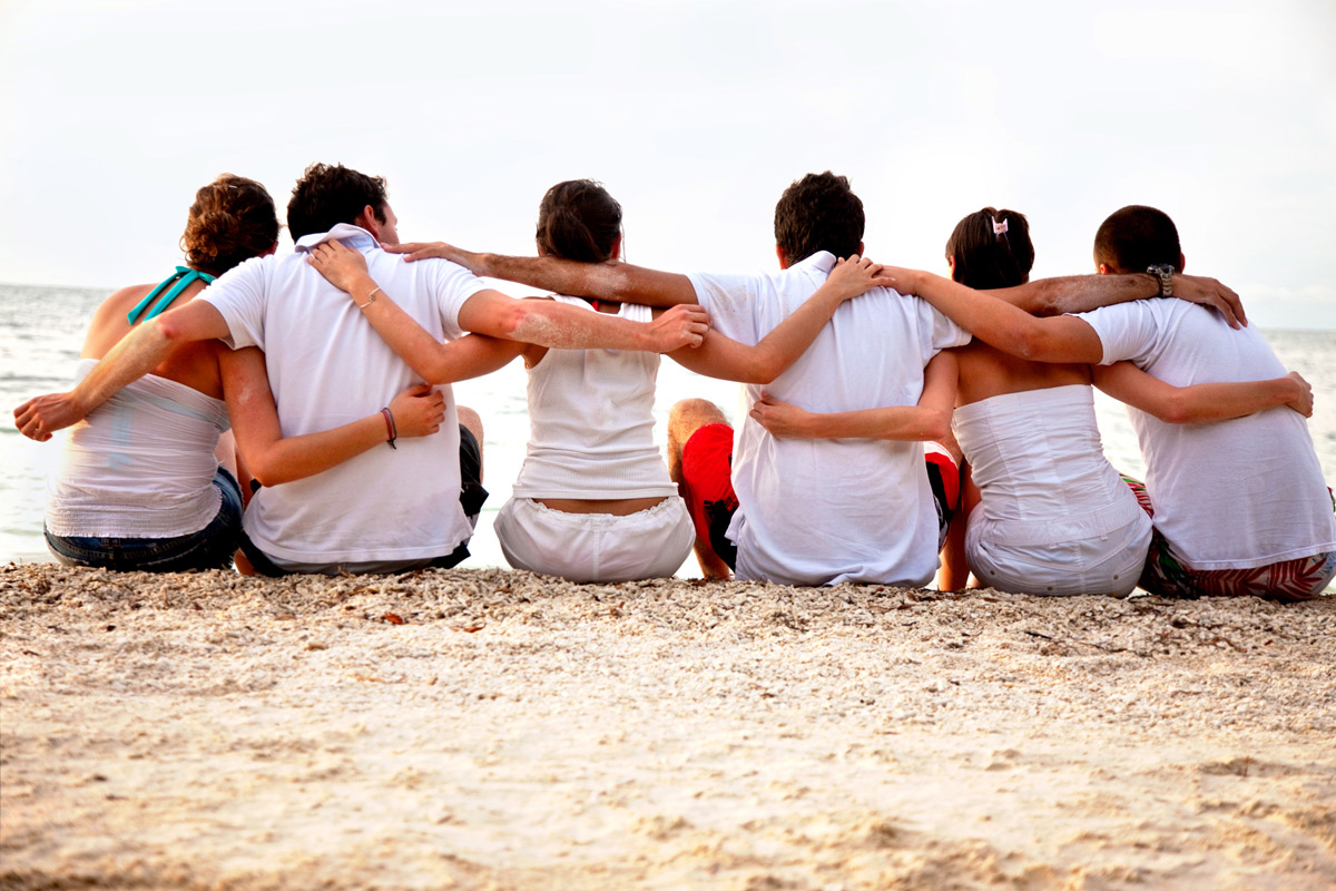 group of individuals embracing on the beach