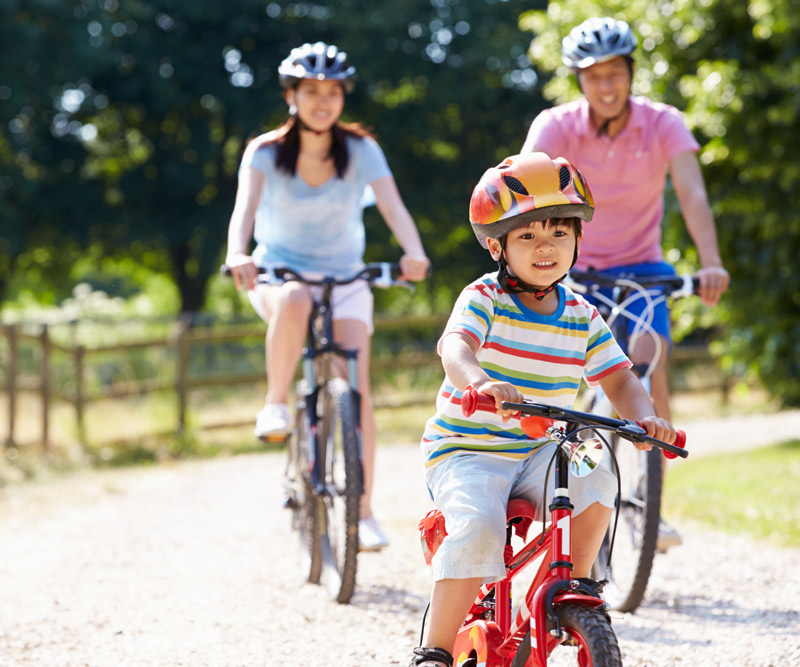 family riding bike in the sun