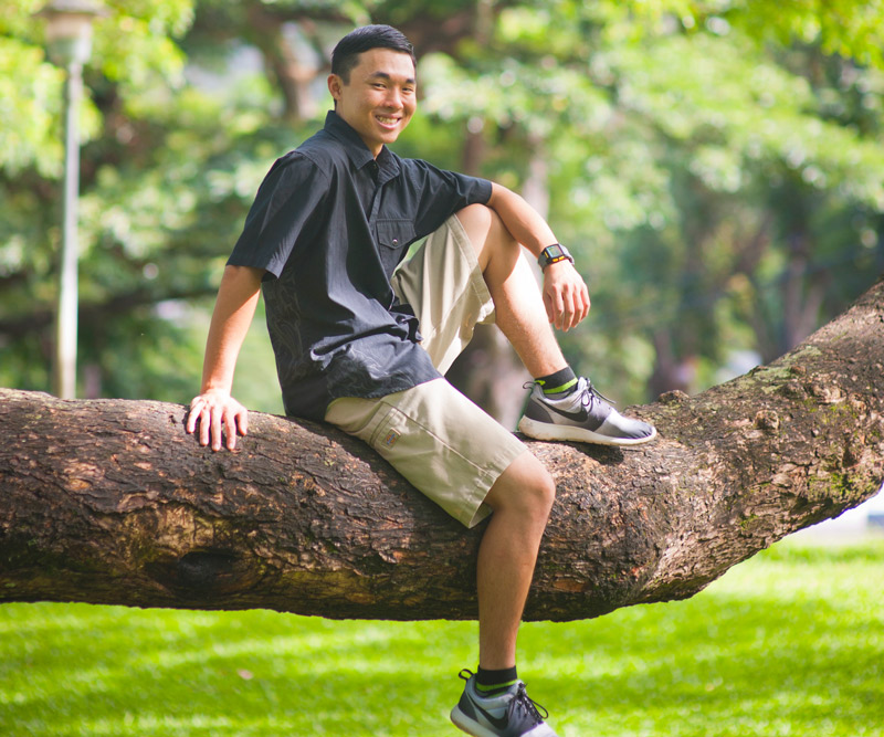 Ryan Nakamura sitting in branch of a tree