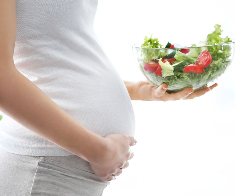 Pregnant Woman holding a healthy salad