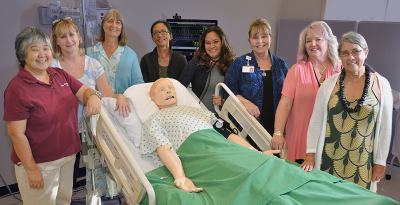 Group of people standing around a simulation mani.