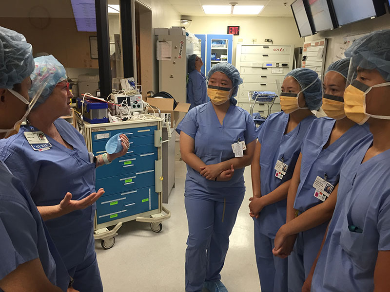a group of medical professionals wearing masks talking to each other