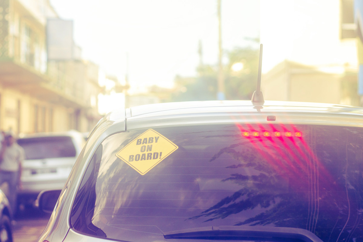 car windshield with sticker that reads baby onboard