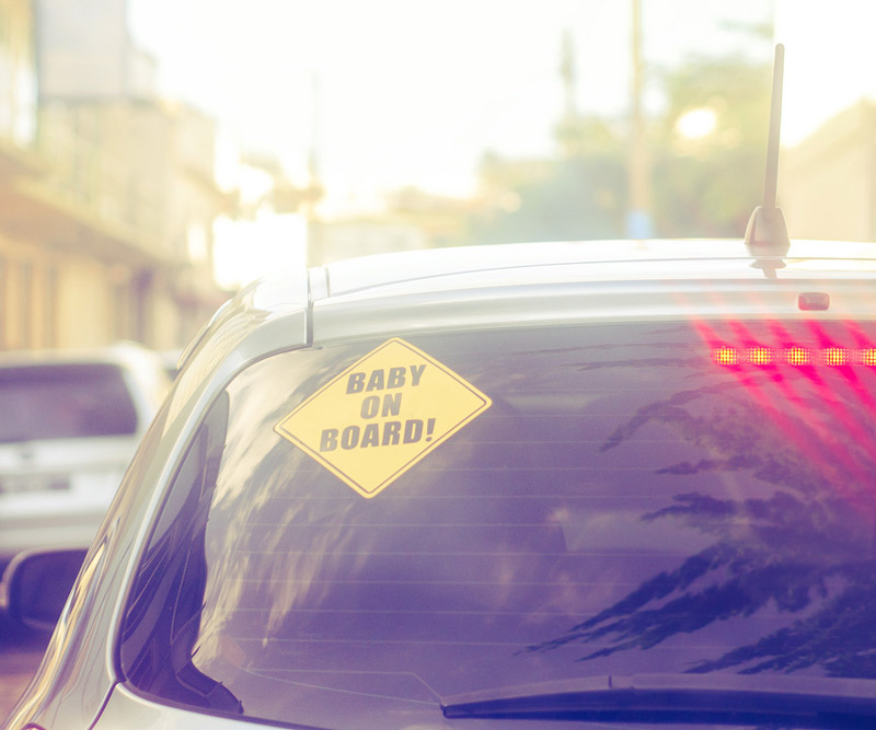 car windshield with sticker that reads baby onboard