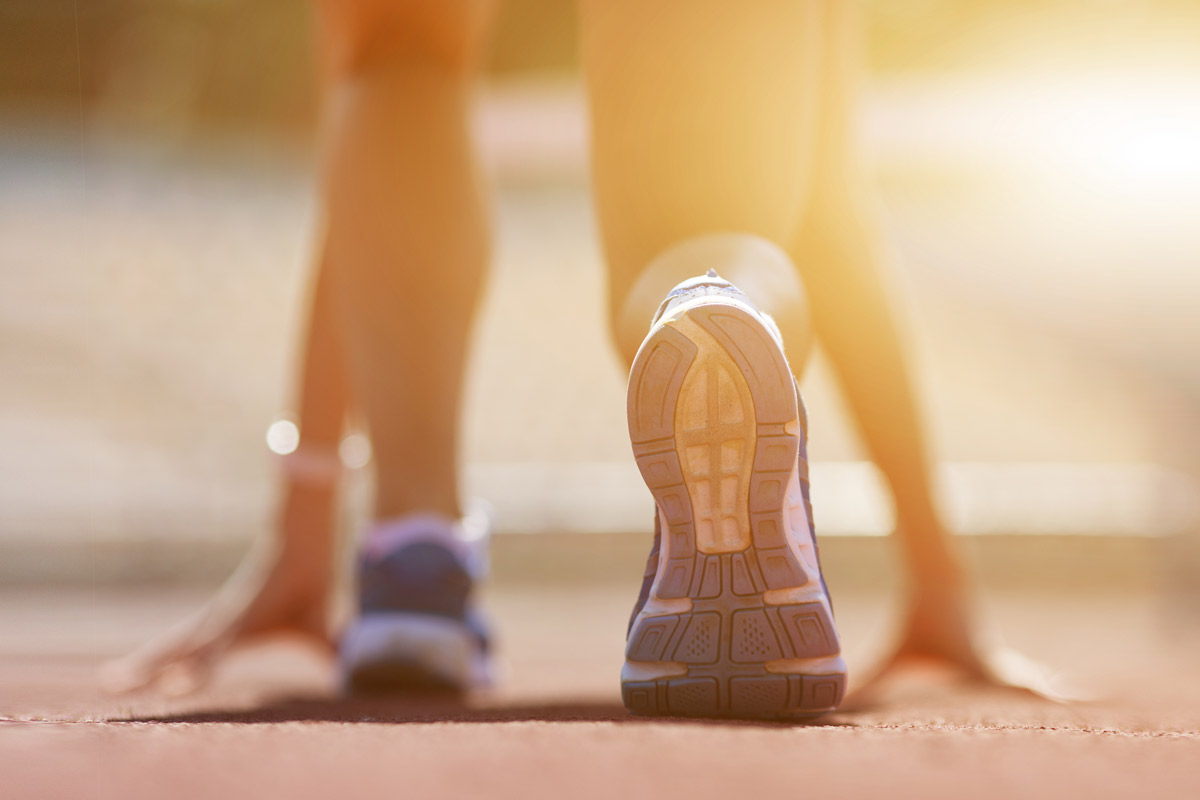 a runner crouches into a starting stance in anticipation for a race