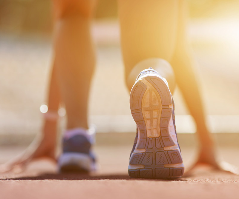 a runner crouches into a starting stance in anticipation for a race