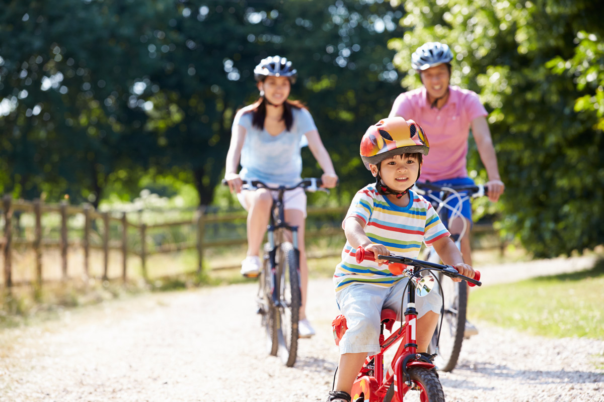 A family riding bike in the sun.