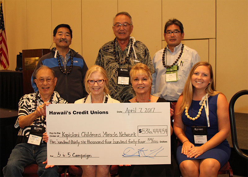 A group of people taking a photo with a donation check for $536,444 from Hawaii's Credit Unions.