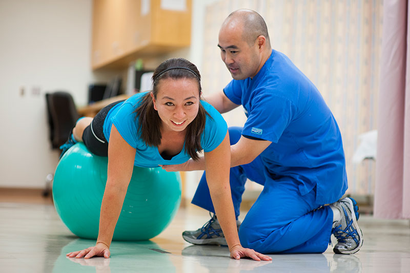 Two people participating in a sports related rehabilitation exercise.