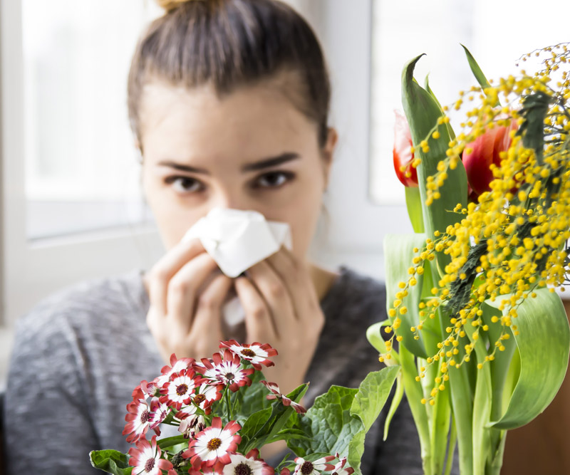 woman blowing her nose into a tissue