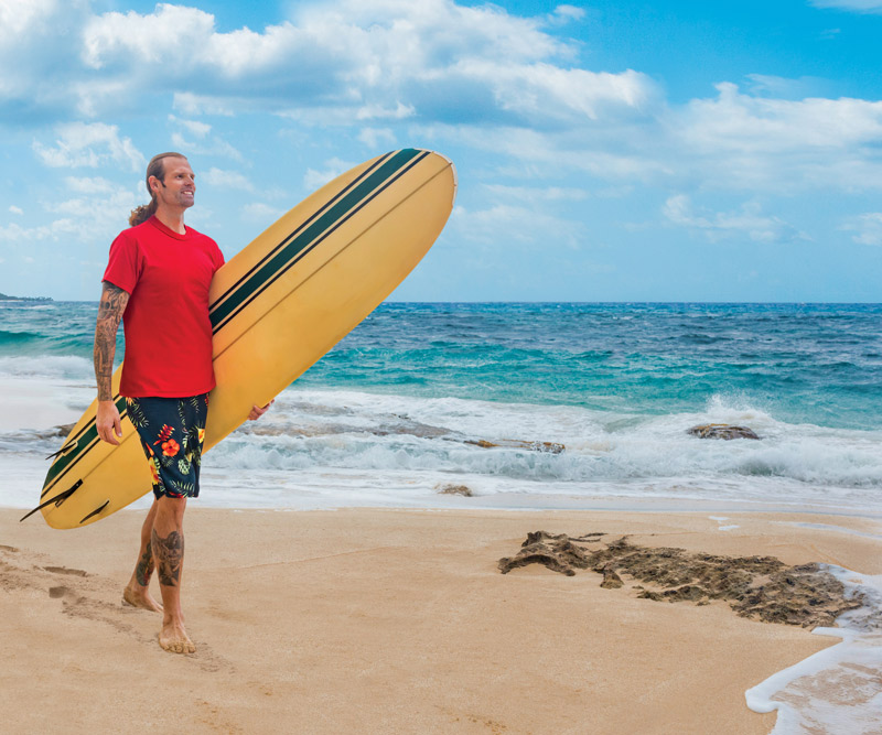 Joseph Blunt walking with surfboard