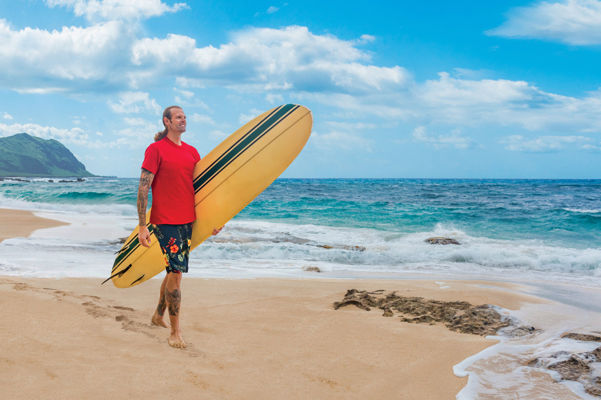 Joseph Blunt walking with surfboard