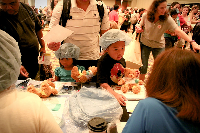 Photo of young children with teddy bears at a public event.