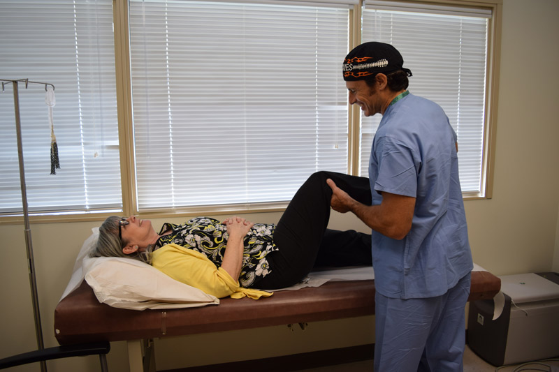 Hip and knee replacement patient with a health professional during a check up.