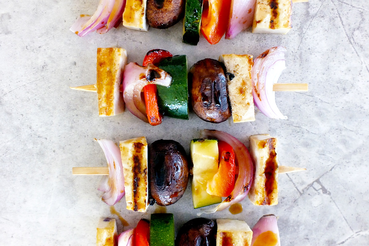 Four Teppanyaki Veggie & Tofu Skewers arranged on a white marble counter top