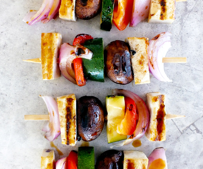 Four Teppanyaki Veggie & Tofu Skewers arranged on a white marble counter top