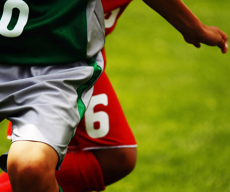 two boys playing soccer together