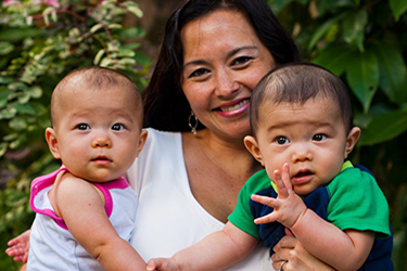 Woman holding two young children