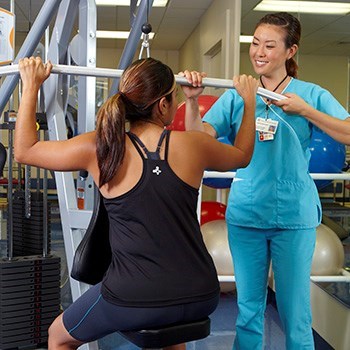 Woman working out in gym with trainer