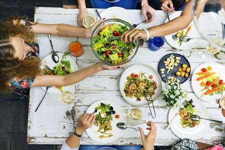 Politely ask to pass the salad, then change the conversation to something other than food – like how much fun you're having!