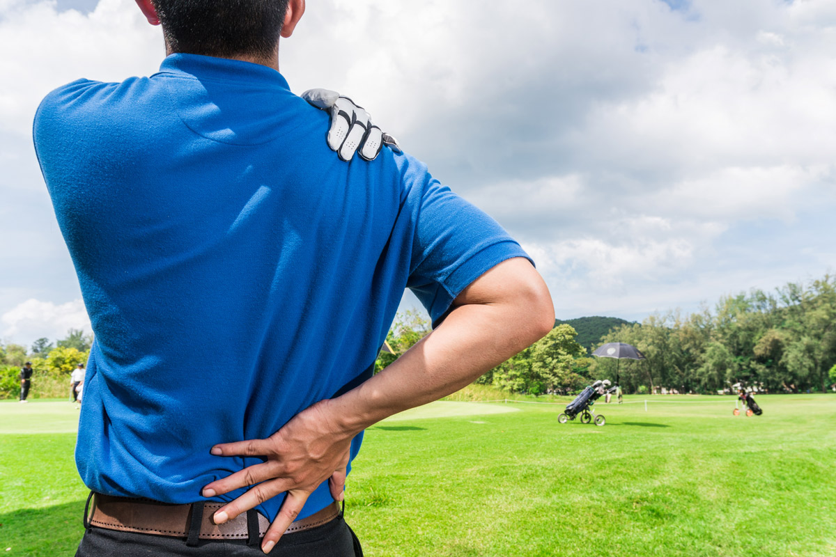 golf player clutching sore back