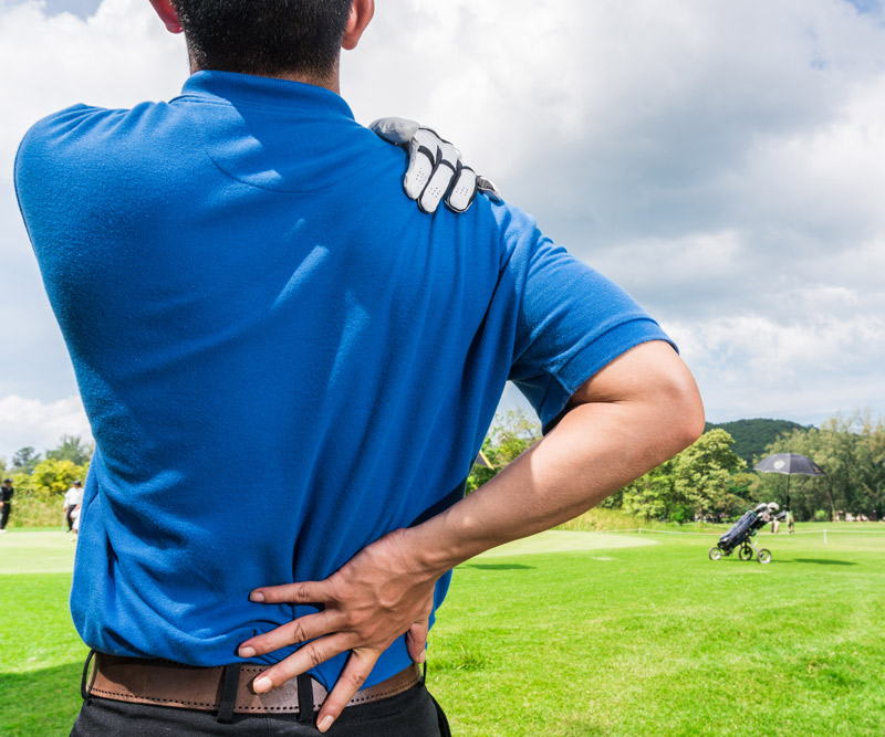 golf player clutching sore back