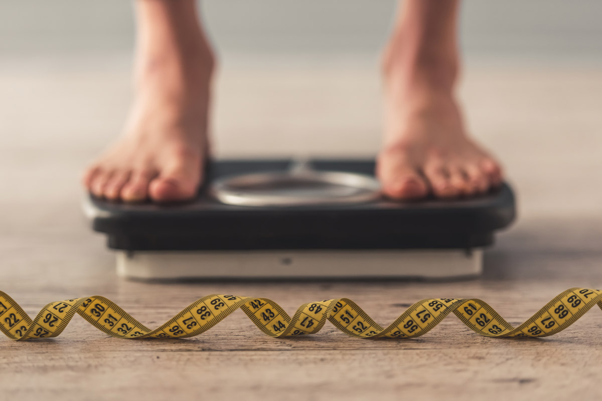 patient checking their weight on a scale