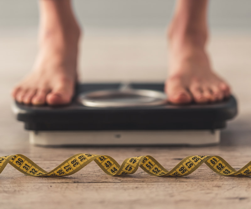 patient checking their weight on a scale