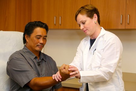 Dr. Alyssa Carnegie examines a patient to assess if he is a candidate for endoscopic carpal tunnel release.