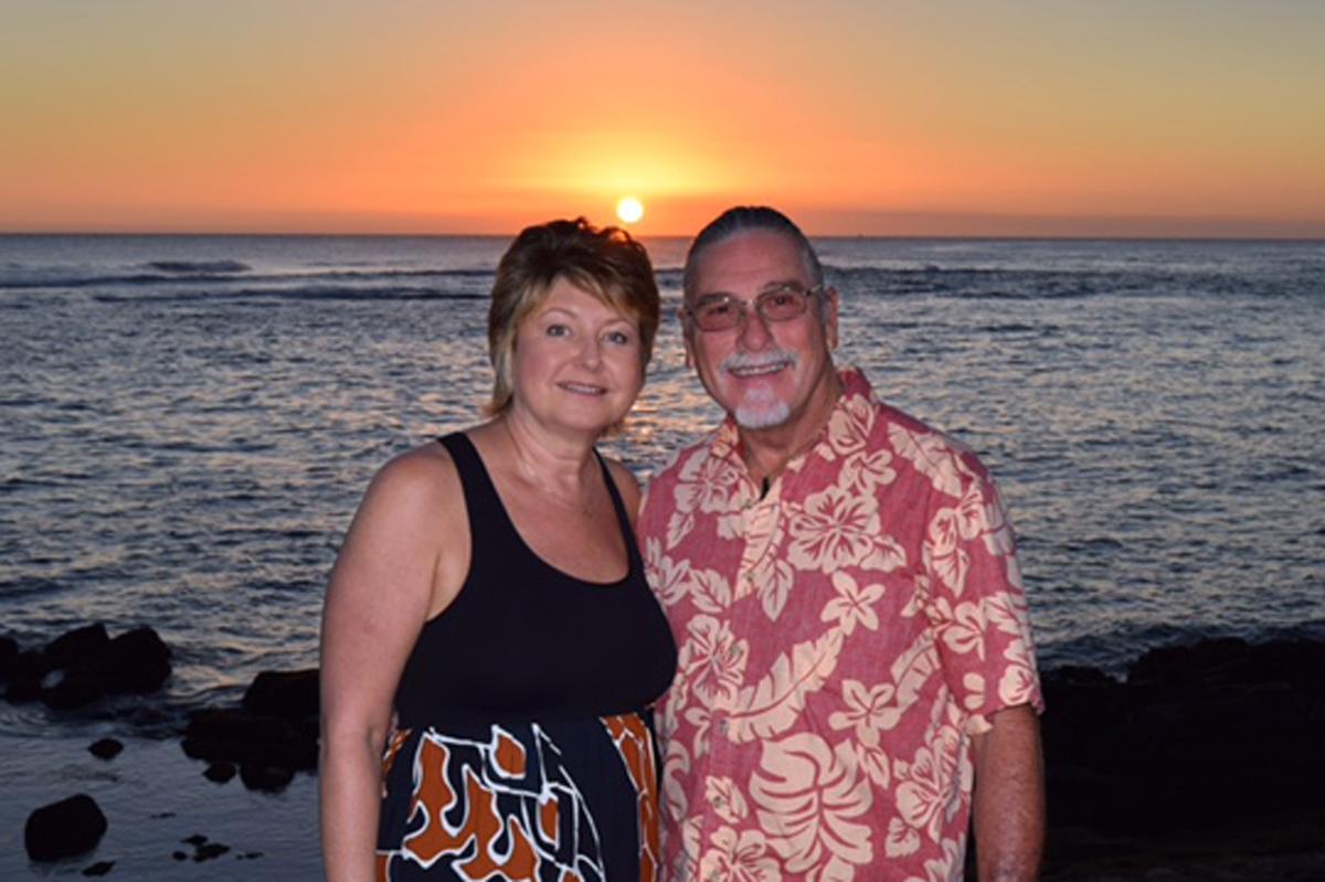 Lorri Pilkington and her husband, Larry, standing by a beach during sunset