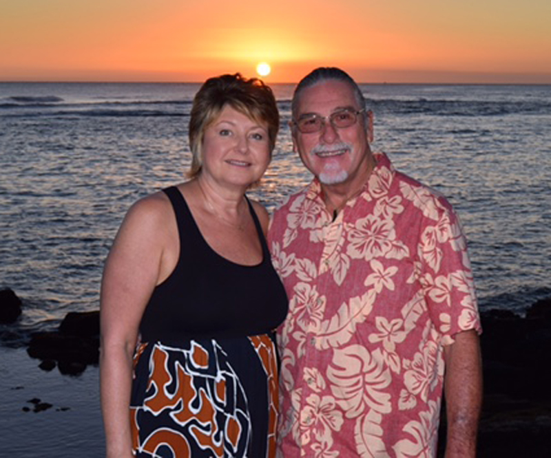 Lorri Pilkington and her husband, Larry, standing by a beach during sunset