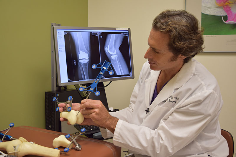Surgeon showing 3-D model of human knee