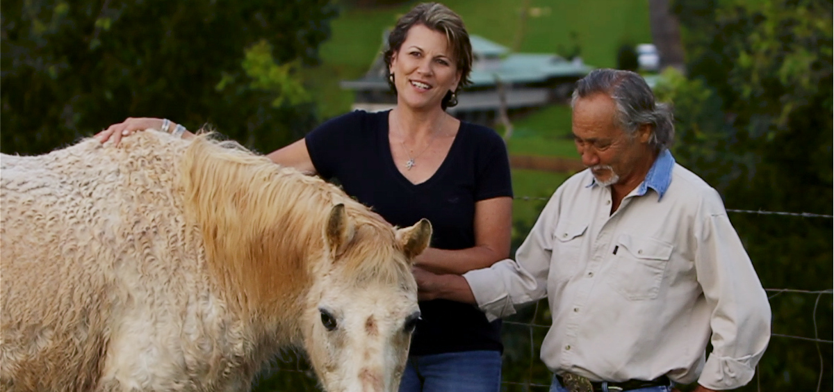 man and woman petting a horse